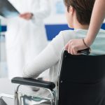 woman being pushed in a wheelchair by an attendant care worker