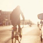 cyclist riding by cars